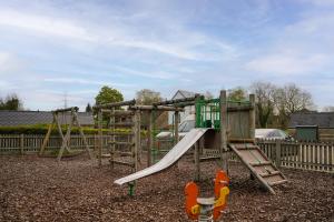 a playground with a slide in a park at Toad Hall Pet-Friendly Family Stay, Lake Access in Somerford Keynes