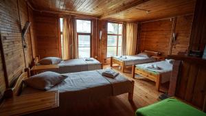 a room with two beds in a wooden cabin at LVM tūrisma un atpūtas centrs "Ezernieki" in Meirāni