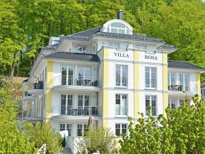ein gelbes und weißes Gebäude mit einem Schild darauf in der Unterkunft Villa Rosa - Apt. 15 in Ostseebad Sellin