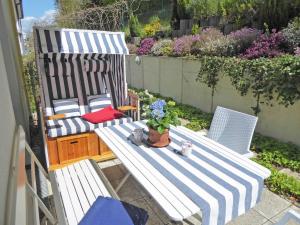 eine Terrasse mit 2 Stühlen und einem Tisch mit Blumen in der Unterkunft Villa Rosa - Apt. 15 in Ostseebad Sellin
