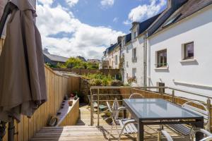 a balcony with a table and chairs on a wooden deck at Ty Marok - Maison pour 4 proche plage in Douarnenez