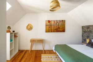 a bedroom with a bed and a table at Ty Marok - Maison pour 4 proche plage in Douarnenez