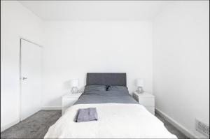 een witte slaapkamer met een groot bed en 2 nachtkastjes bij Home Away From Home Local To A Lot Of Amenities in Stoke on Trent