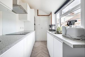 a kitchen with white cabinets and a toaster on a counter at Home Away From Home Local To A Lot Of Amenities in Stoke on Trent +9 photos