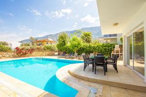 a villa with a swimming pool and a table and chairs at Villa Valley 5 in Oludeniz
