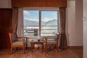 a room with a table and chairs and a large window at Mount View Pokhara in Pokhara