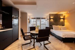 a bedroom with a bed and a table and chairs at Midtown Hotel Royal Room in Amsterdam +9 photos