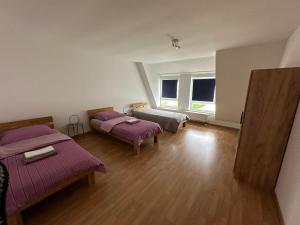 a room with two beds and a large window at Großes Apartment im DG in Leipzig