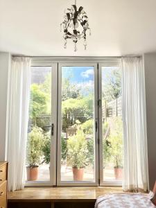 1 dormitorio con una gran ventana con cortinas blancas en Bright 1BR Flat wPatio in Islington, Angel en Londres