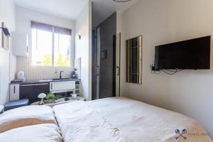 una camera con letto e TV a schermo piatto di Tiny & Cosy studio Neuilly sSeine a Neuilly-sur-Seine