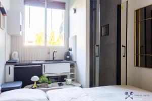 ein Schlafzimmer mit einem Bett und einem Waschbecken sowie eine Küche in der Unterkunft Neuilly sSeine - Inkermann in Neuilly-sur-Seine