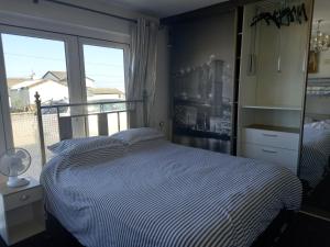 1 dormitorio con cama y ventana grande en Seascape, en Letterkenny