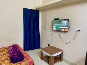 Cette chambre dispose d'un canapé, d'une télévision et d'une table. dans l'établissement The Lakeview Apart-Hotel, à Agartala