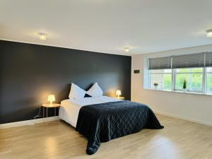 a bedroom with a bed with a black accent wall at aday - Modern and Charming 5 bedrooms Villa 