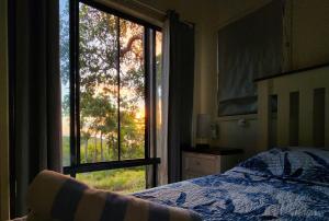 - une chambre avec un lit et une grande fenêtre dans l'établissement Our Beach House K'gari, à Fraser Island