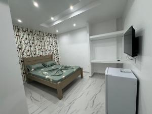 1 dormitorio con 1 cama y TV en Pereira lounge bar, en Praia