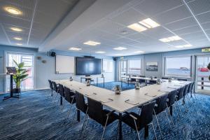a conference room with a long table and chairs at HOTEL SØMA Aasiaat in Aasiaat
