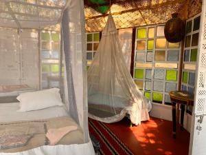 1 dormitorio con 1 cama con mosquitera en Cozy Nook Goa Palolem, en Palolem