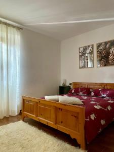 Un dormitorio con una cama con sábanas rojas y una ventana en Casa Lorenzo en Sondalo