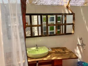a bathroom with a green sink and a mirror at Cozy Nook Goa Palolem in Palolem