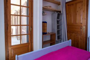 una camera da letto con un letto con lenzuola rosa e una porta di 3 Olive Trees - Sithonia a Ormília
