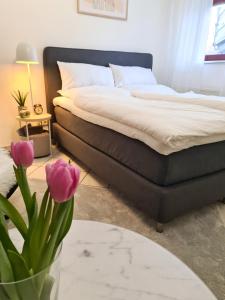 キツヒハインにあるFerienwohnung Rote Tür - Landleben pur!のベッドルーム1室(ベッド1台付)、紫の花の花瓶1枚