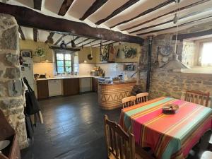 a kitchen with a table and a kitchen with a counter at Apaizetxea, caserío en entorno rural entre Bilbao y Vitoria-Gasteiz in Andagoya
