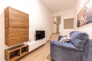 a living room with a blue chair and a television at ORSOLA - New 2 BEDROOM Apartment in Valletta