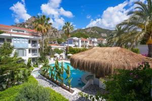 a resort with a swimming pool and a straw umbrella at Kassandra Boutique Hotel in Oludeniz