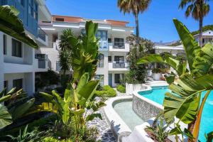 an apartment complex with a swimming pool and palm trees at Kassandra Boutique Hotel in Oludeniz