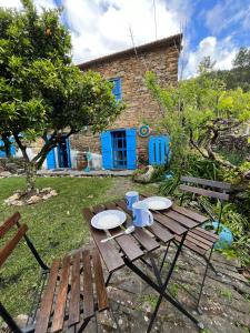 a wooden picnic table with two plates on it in a yard at Refúgio da Estrela in Aguincho