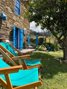 a group of lawn chairs sitting in front of a building at Refúgio da Estrela in Aguincho +45 photos
