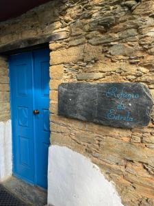 a blue door on the side of a stone building at Refúgio da Estrela in Aguincho