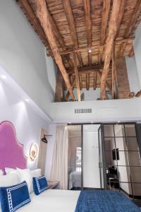 グラナダにあるHotel Casa Palacete Tablasの木製の天井のベッドルーム1室(ベッド1台付)