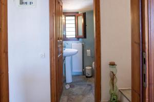 un piccolo bagno con lavandino e specchio di 3 Olive Trees - Sithonia a Ormília Altre 61 foto