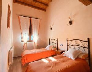 a bedroom with two beds and a window at Casa Rural Lucia in La Horcajada