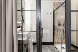 a bathroom with a glass shower door and a toilet at Hotel Casa Palacete Tablas in Granada