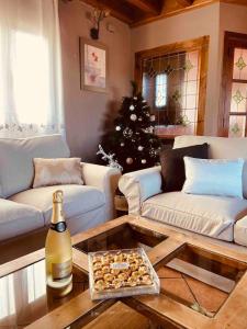 uma sala de estar com uma garrafa de champanhe e uma árvore de Natal em Casa Rural Lucia em La Horcajada