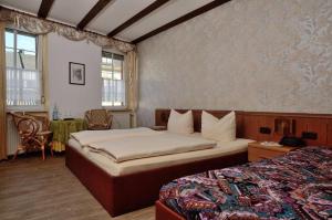 a hotel room with two beds and a table and chairs at Weinhaus Hotel zum Josefshof in Graach