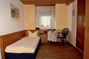 a room with a bed and a table and a window at Weinhaus Hotel zum Josefshof in Graach