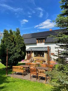 a patio with benches and tables in front of a building at Trapani house & camp in Růžová