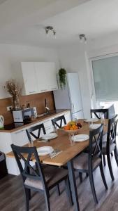 uma cozinha com uma mesa de madeira e cadeiras numa cozinha em Apartmani Franka em Privlaka