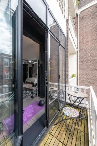 una porta aperta su un balcone con tavolo e sedie di Museum Square View B&B ad Amsterdam