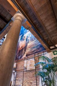 una pintura en la pared de un edificio con un pilar en Hotel Casa Palacete Tablas en Granada