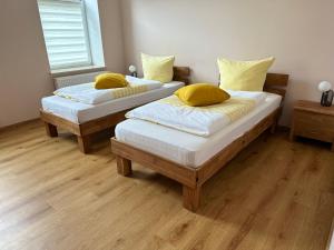 ボルナにあるSchöne 2 Raumwohnung in Bornaの黄色い枕付きのベッド2台が備わる客室です。