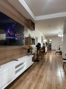 sala de estar con TV de pantalla plana grande en Residência Wimbledon, en Ilhéus
