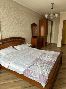 a bedroom with a large bed with a dresser and a mirror at guest house djal in Bishkek