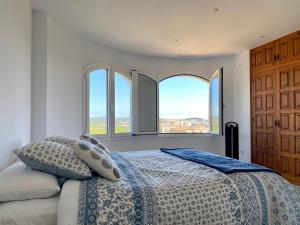 a bedroom with a bed and two large windows at Villa Saramel con vistas panorámicas al mar in Sant Antoni de Calonge +51 photos
