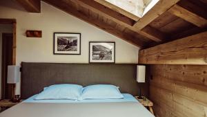 a bedroom with a bed with a wooden wall at L'Alpaga, a Beaumier hotel in Megève