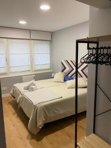 1 dormitorio con 1 cama y 2 ventanas en La Casa de Carola, en Bilbao